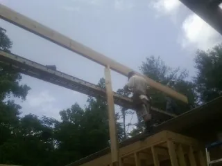 Carpenter setting a ridge beam over a new addition frame — Ice Dam Removal by Roofing Brothers in Mount Sherman