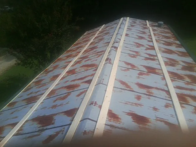 Rusted metal roof panels with new wood purlins before replacement — Storm Damage Roof Repair in Mount Sherman by Roofing Brothers