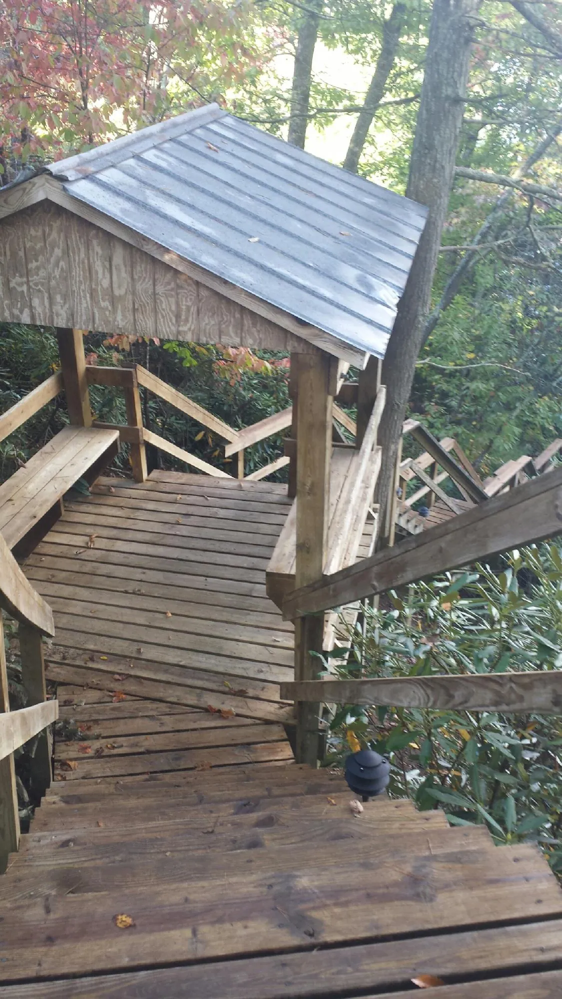 Metal roofed shelter over wooden steps on a wooded walkway — Skylight Repair & Installation work by our crew in Mount Sherman