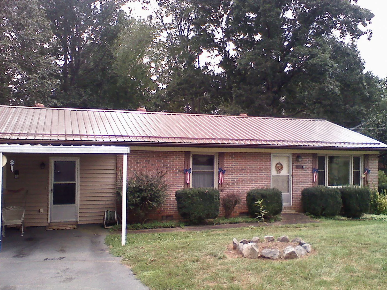 Bronze metal roof and carport on a brick ranch home — Roof Repair work by our crew in Mount Sherman