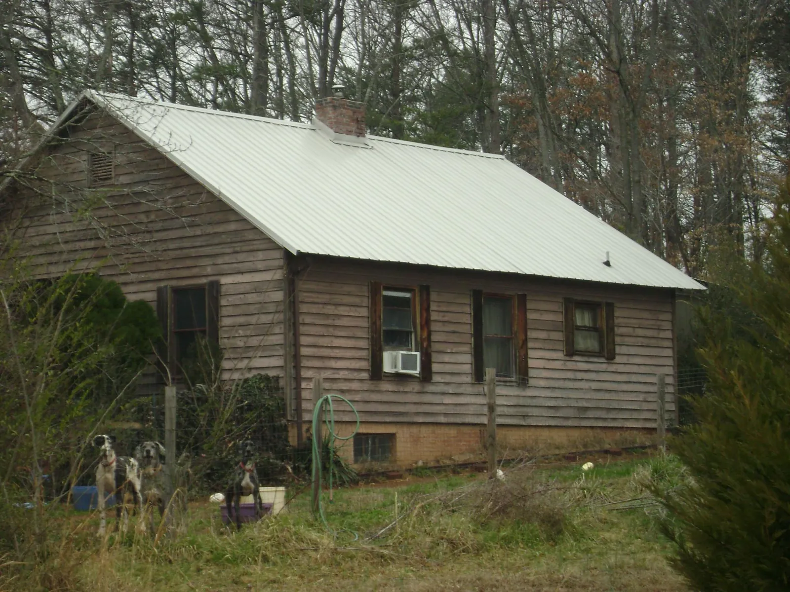 White metal roof on an old wood sided farmhouse, from a Metal Roof Installation job in Mount Sherman